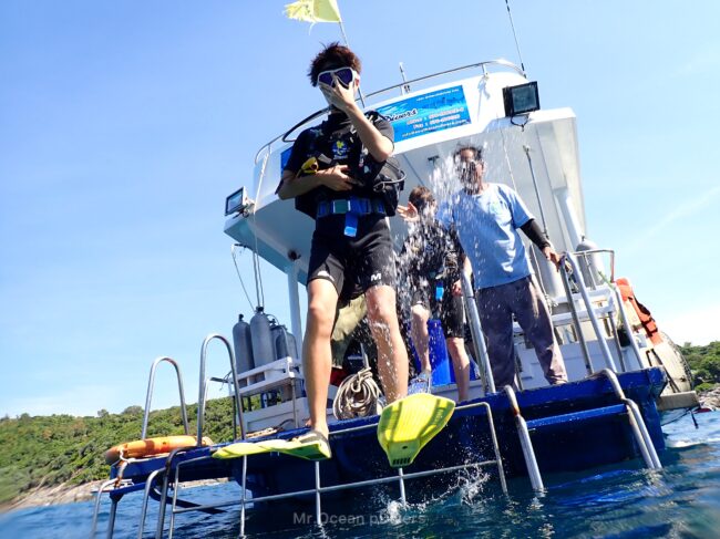 船から1人のダイバーが海へ飛び込んでいるのが見えます